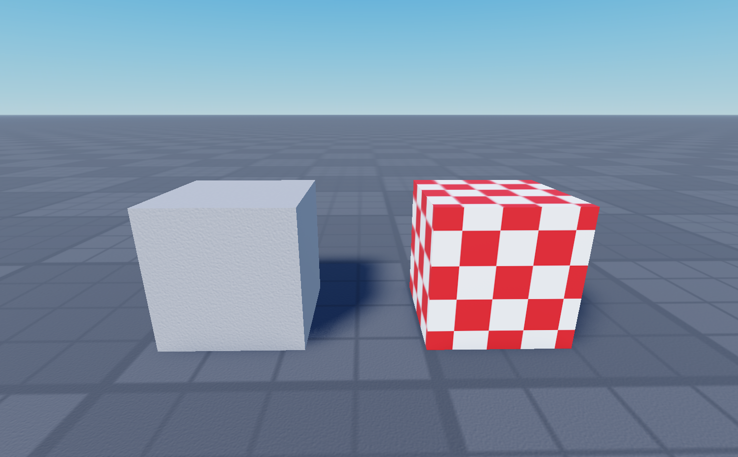 A grey cube target beside the checker layered mesh deformed onto it, in Studio.